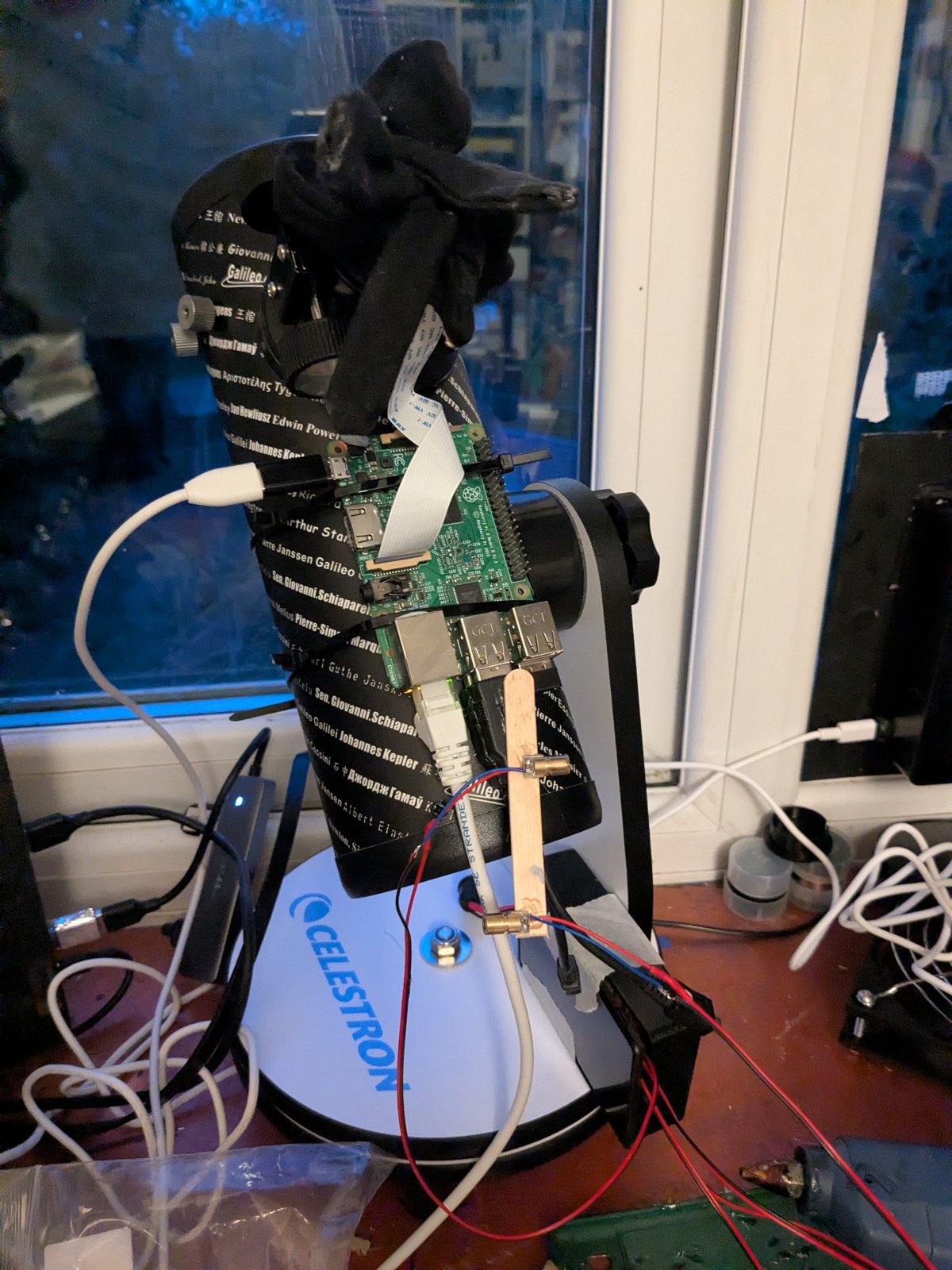 The FirstScope with a craft stick under the Pi holding two small brass lasers, one pointing to each side
